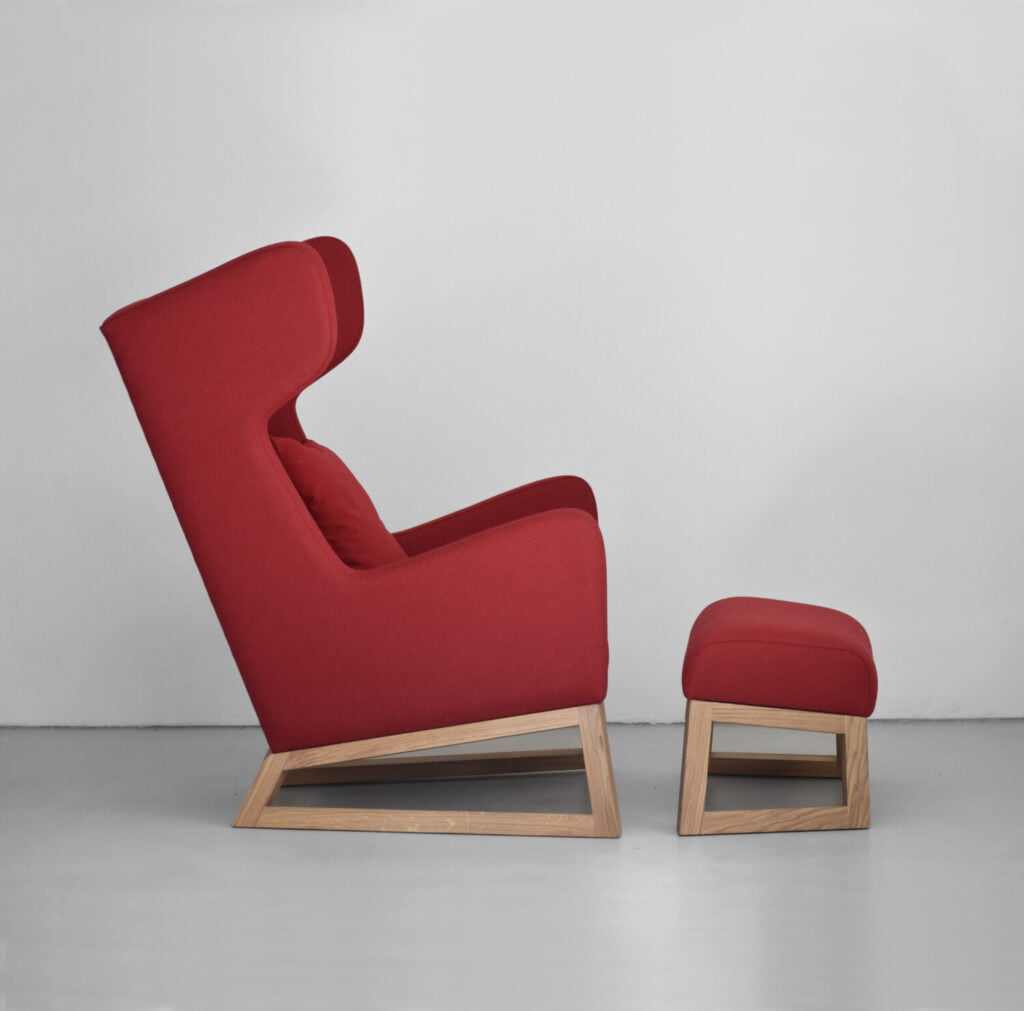 czerwony fotel, fotel uszak na dębowych nogach, nowoczesny fotel uszak, fotel z podnóżkiem